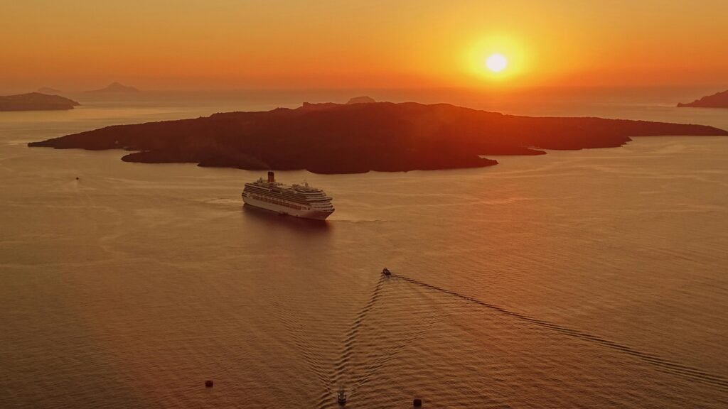 greece-santorini-architecture-island-161342-161342 A breathtaking sunset view of a cruise ship near the island of Santorini, Greece.