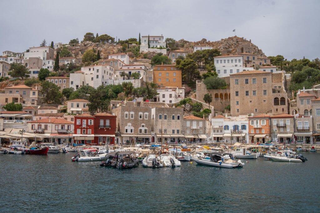 Charming waterfront view of a Greek town with boats and traditional houses.